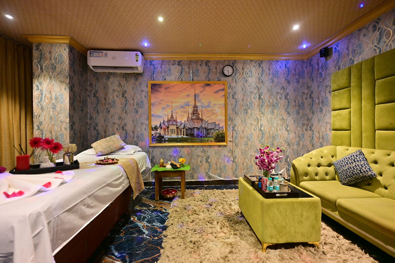 Massage room with Thai temple painting and green velvet sofa